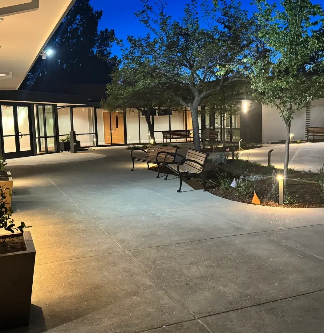 Courtyard with benches and trees at dusk.