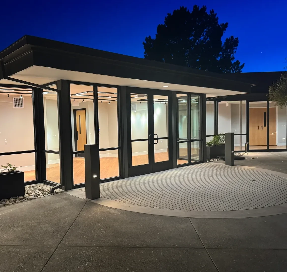 Modern building entrance illuminated at night.