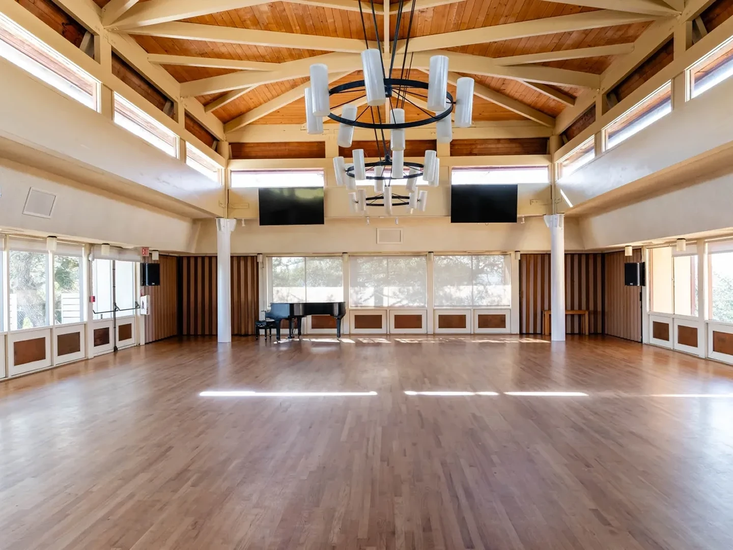 Spacious room with wooden floors and piano.