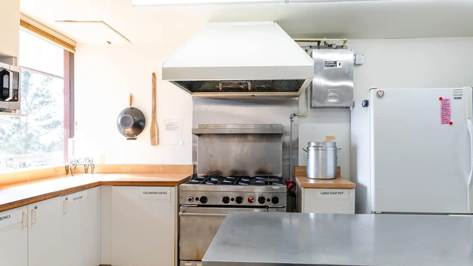 Commercial kitchen with stove and stainless counter.