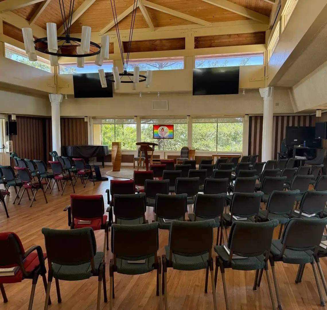 Conference room with arranged chairs and screens.