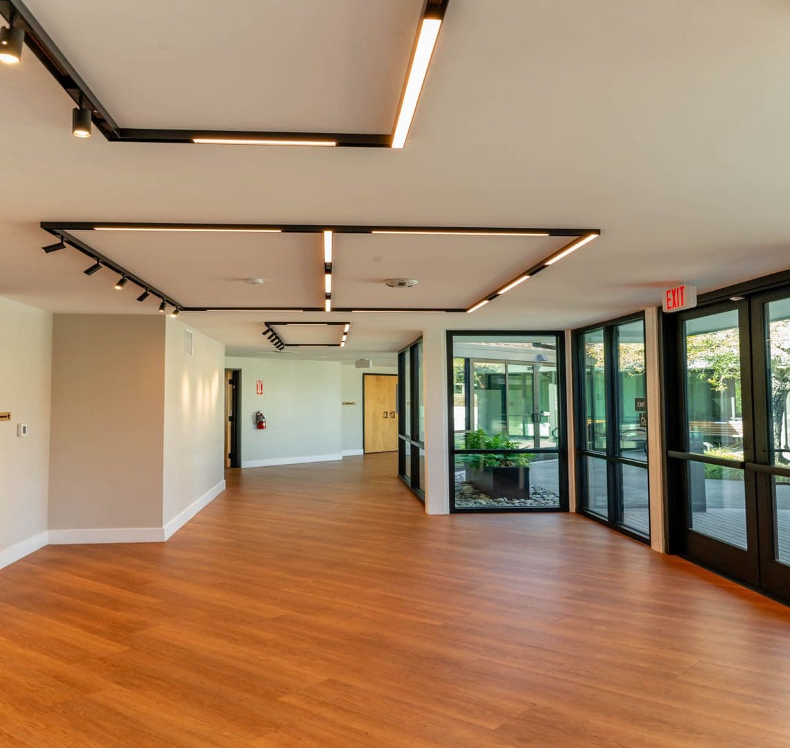 Modern lobby with wooden flooring and lights.